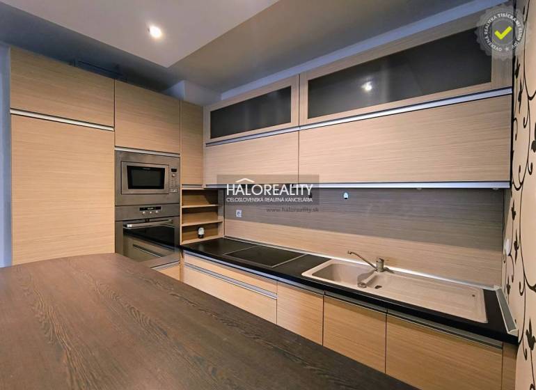 A kitchen in a 2-room apartment with a wooden decor floor and built-in appliances.