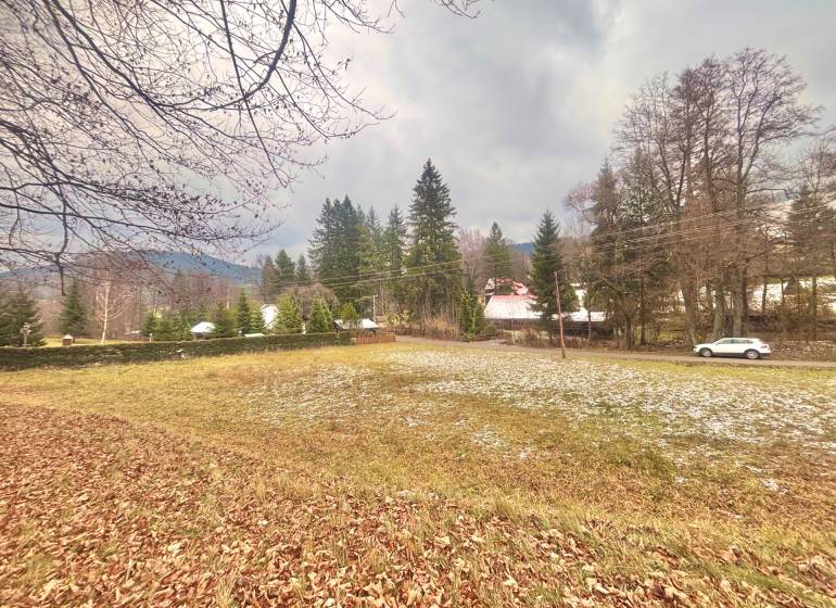 Autumn panorama of residential plots in Makov, Čierne, surrounded by trees and a road with a car.