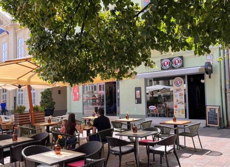 The terrace of the restaurant under the trees at Hlavná 74 in Košice - Old Town district.