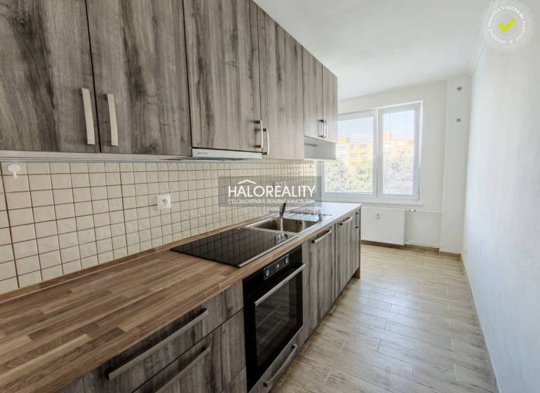A kitchen in a 2-room apartment with a kitchen unit and a floor with a wooden decor.