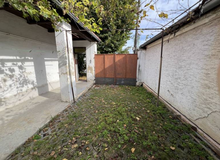 The courtyard of a family house in Jablonec with stone paving and greenery.