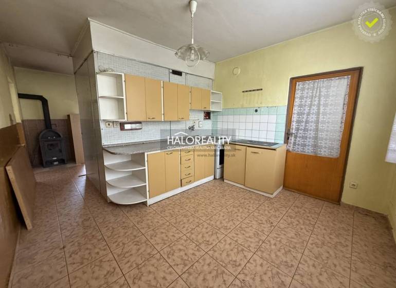 A kitchen with tiles and a wooden cabinet in a 3-room apartment.