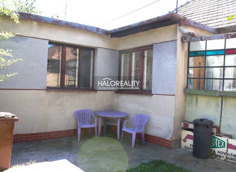 Family house in Trnava, outdoor yard with a plastic table and chairs, flower pot.