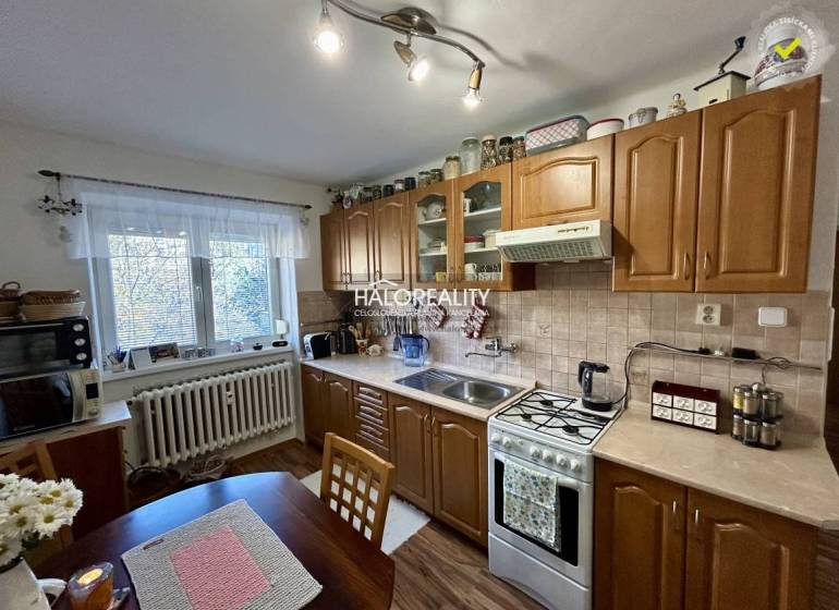 A kitchen in a 2-room apartment with a wooden floor decor and classic cabinets.