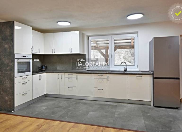 A kitchen in a family house with modern appliances and a wooden decor floor.