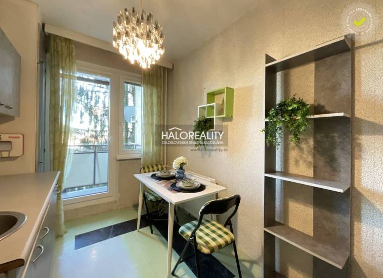 Dining area with a small table and chairs in a 3-room apartment.