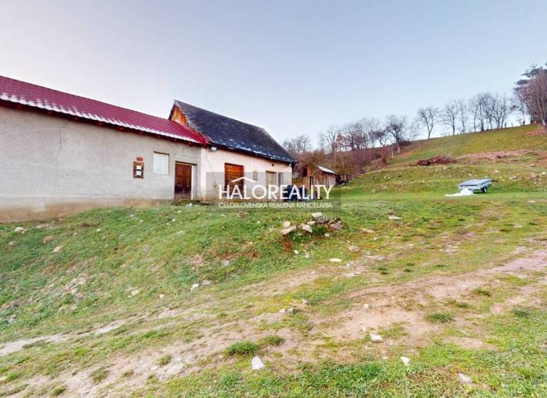 A family house in Klenovec on a slope, with a nearby bench and green surroundings.