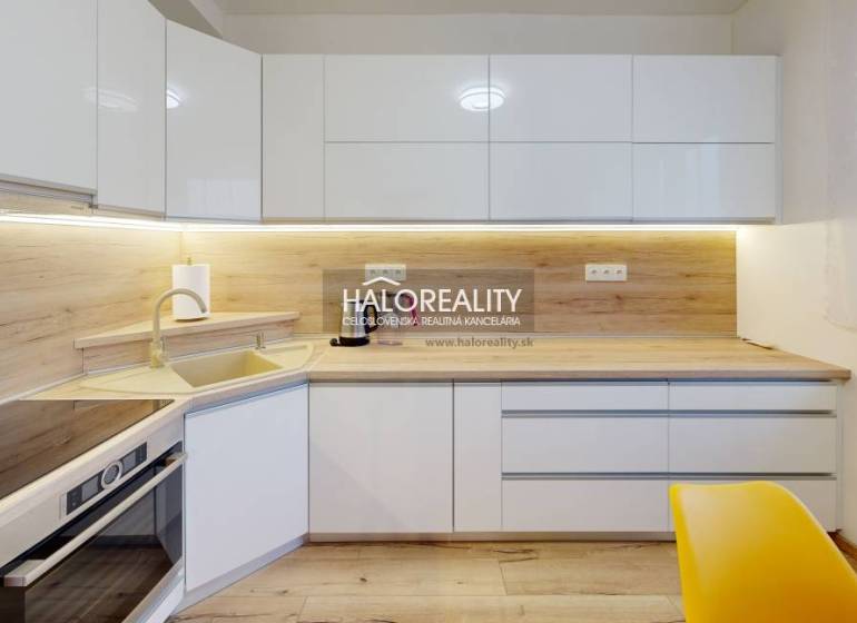 White kitchen with wood-patterned flooring in a 2-room apartment with modern lighting.