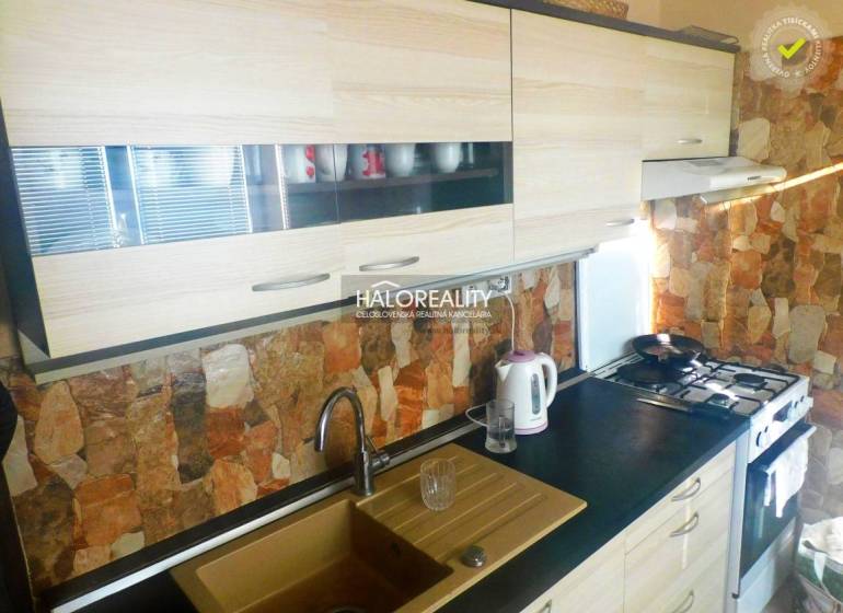 A room in a 2-room apartment with a wooden decor floor, a television, and built-in wardrobes.