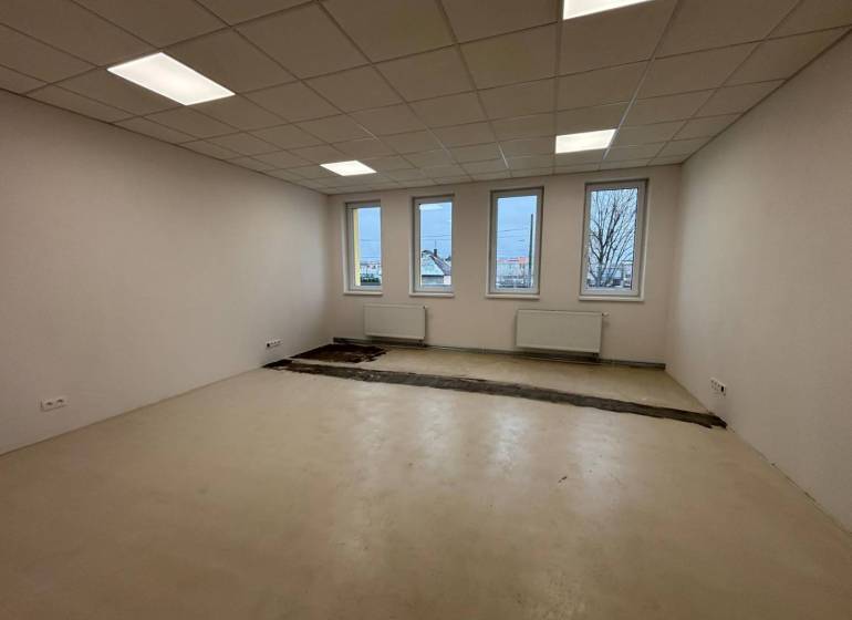 Offices with white walls, floors, and windows, waiting to be completed.