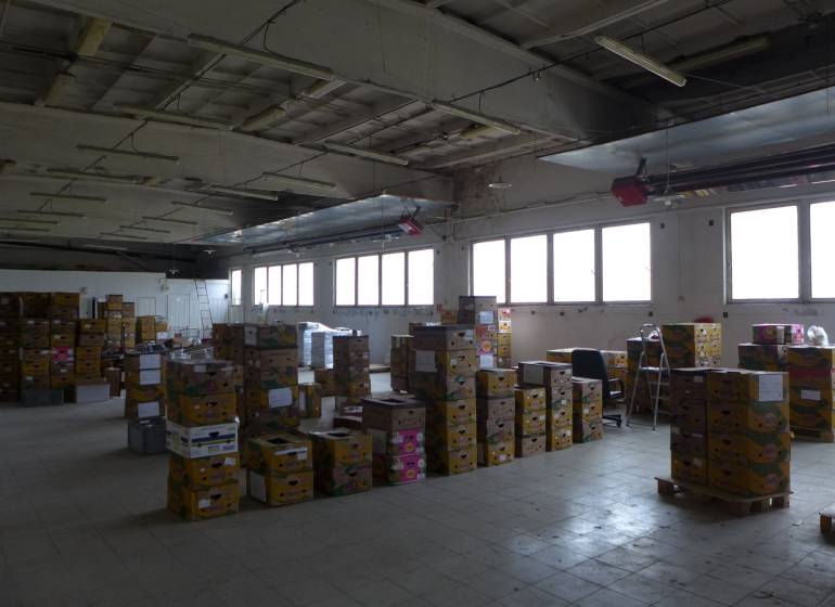 A spacious interior of warehouses and halls with a lot of stacked boxes.