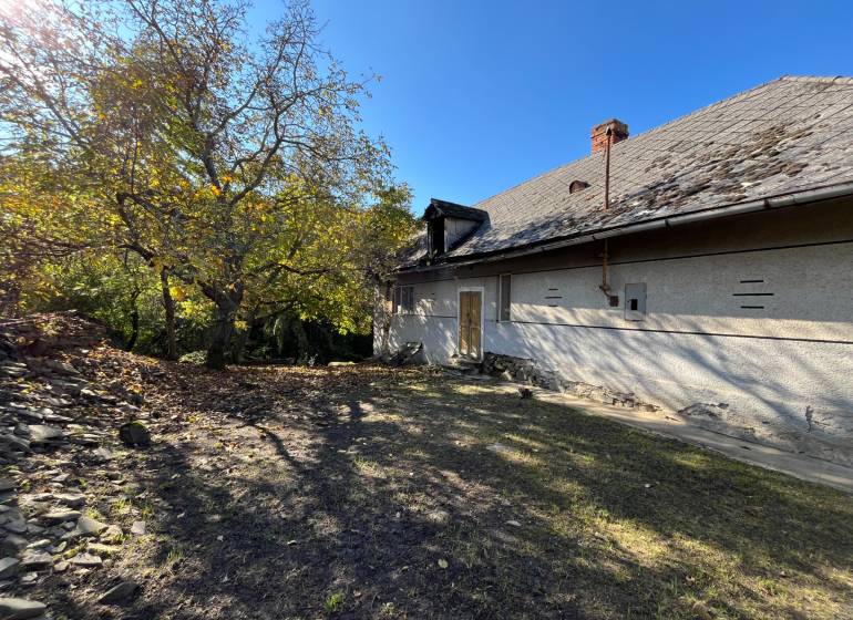 A yard with a house in Rákoš, surrounded by greenery. Land - residential.