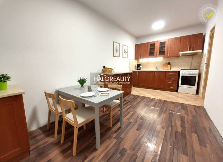 A kitchen in a 2-room apartment with a wooden decor floor and a dining table.