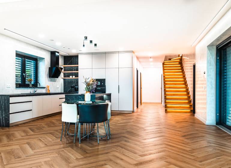 Interior of a family house with a kitchen, staircase, and floor with a wood decor.