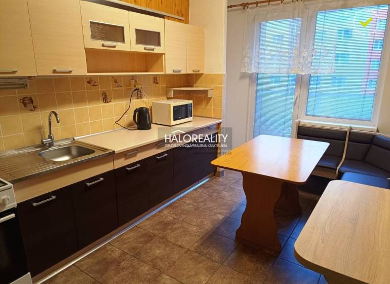 A kitchen in a 3-room apartment with light cabinets, a corner bench, and a floor with a wood decor.