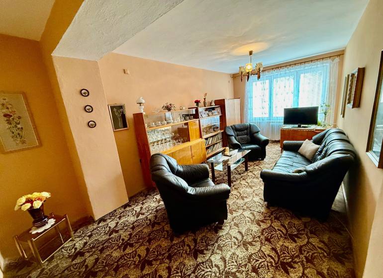 Living room in a two-room apartment with a sofa set and a glass display cabinet.