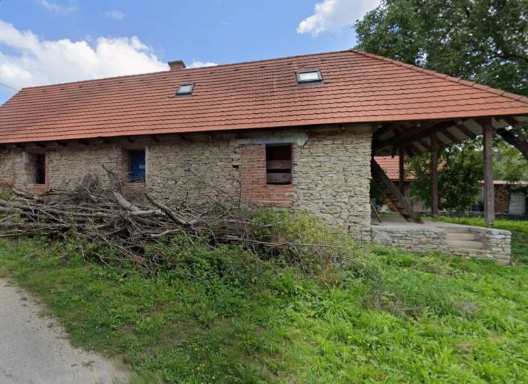 A cottage in Zliechov with stone walls and a sloping red roof.