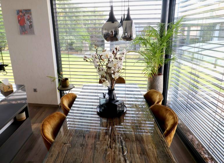 Dining table with flowers, wooden decor floor, family house.