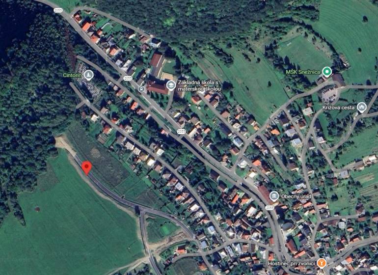Aerial map of development plots in Snežnica, surrounded by greenery and adjacent buildings.