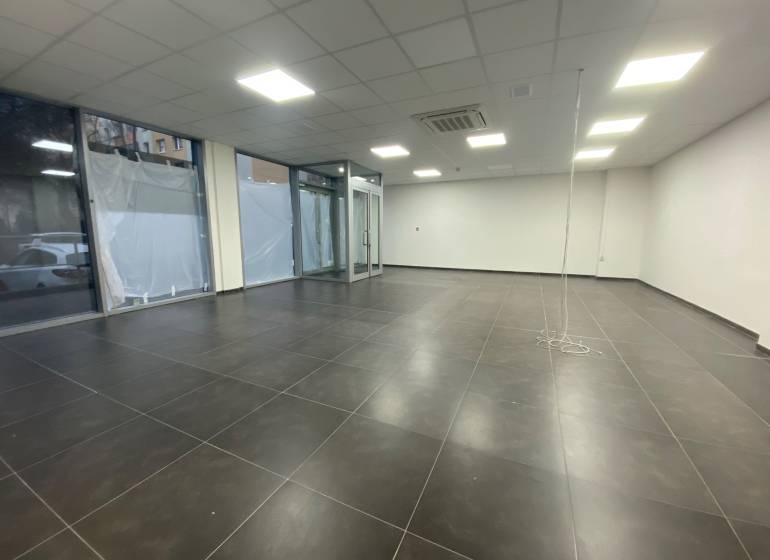 Commercial spaces with dark tiles, white walls, and glass displays.