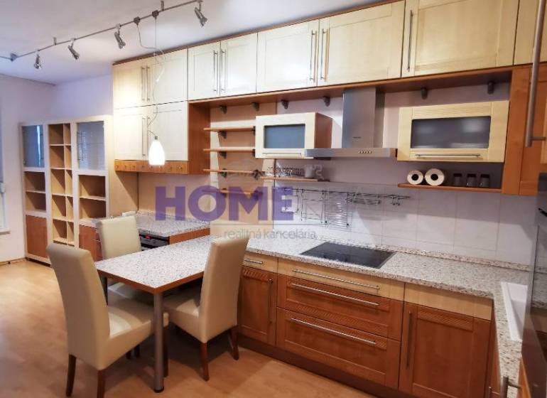 A kitchen unit with a wooden decor and a dining table in a 2-room apartment.