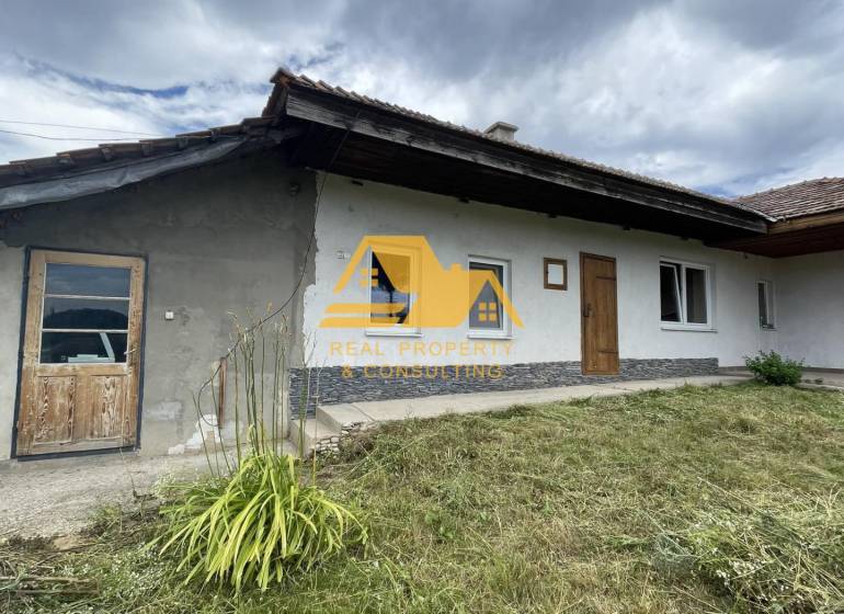 A family house in Svodín on Svodinská Street with a grassy front garden under a cloudy sky.