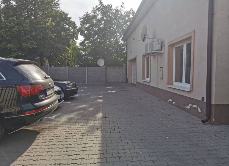 Parking lot near the offices on Šamorínska Street in Senec with cars and trees in the background.