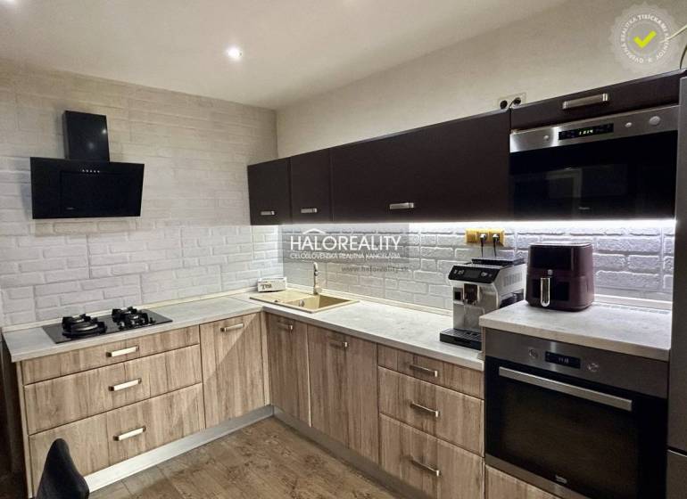 A kitchen in a 3-room apartment with a wooden decor and a white brick wall cladding.