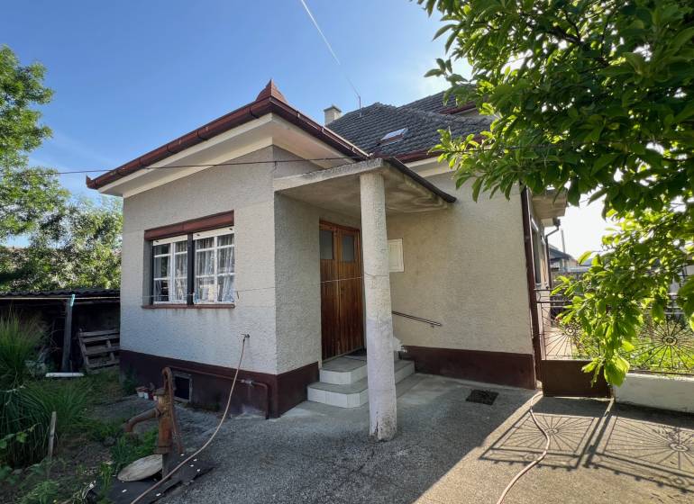 A family house in Drahovce on Drahovce Street with a garden and a narrow entrance gate.