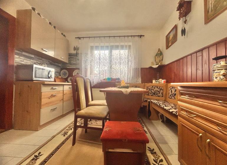 A kitchen in a family house with a corner bench, a microwave, and decorative elements.
