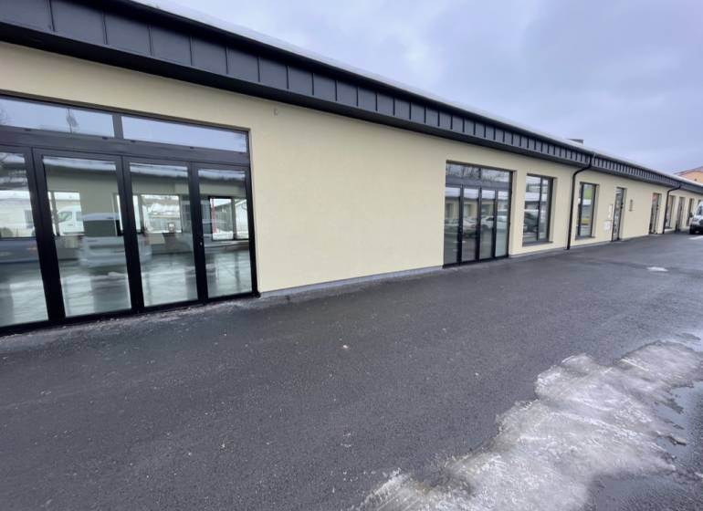 Commercial premises on Jarmočná Street in Stará Ľubovňa with glass display windows and a parking lot.