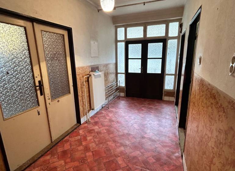 Hallway in a family house with a colorful floor and large glass doors.