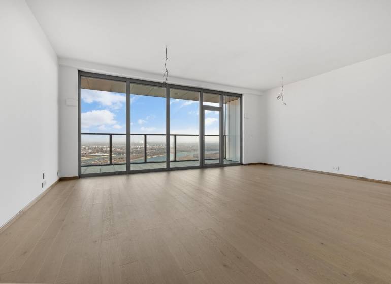 A spacious living room in a 3-room apartment with glass doors and a wooden decor floor.