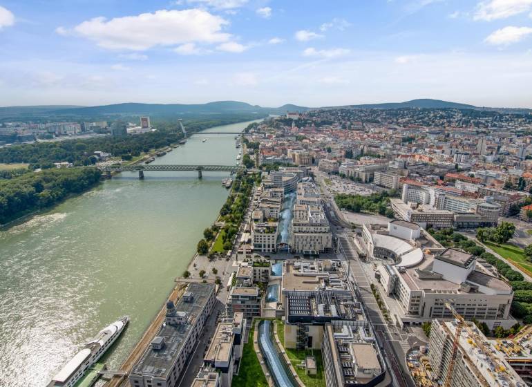 Aerial view of Bratislava across the river with a view of Pribinova and city architecture.