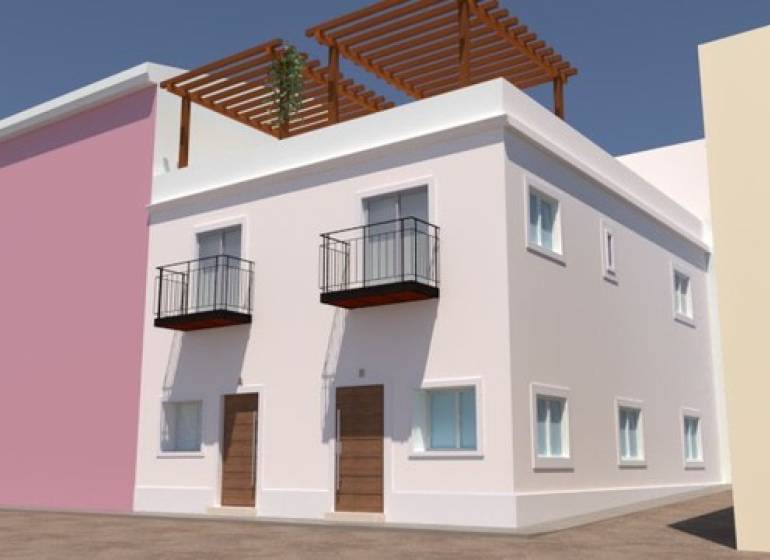 A family house in Villajoyosa with balconies, wooden doors, and a terrace with a pergola.