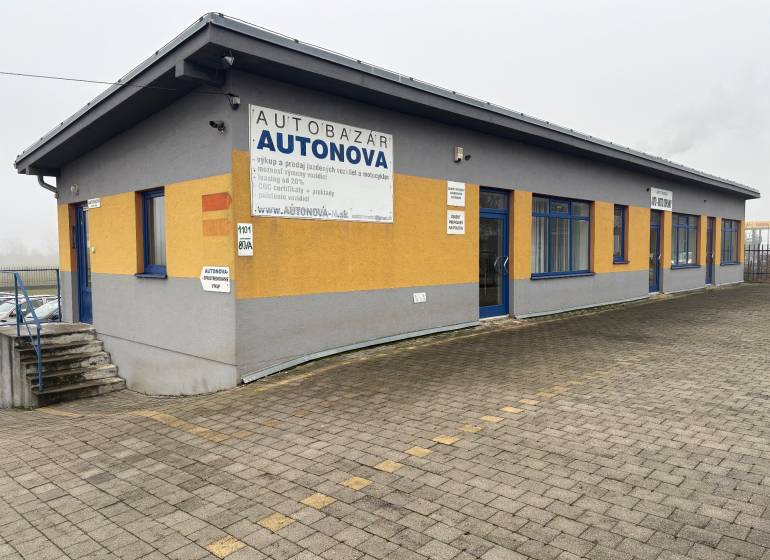 The car dealership on Bratislavská Street in Veľký Biel is surrounded by a paved area.