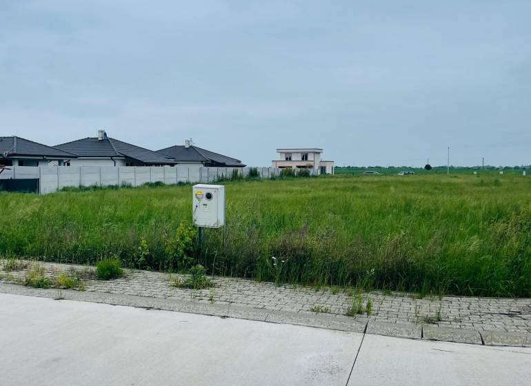 Plots - housing on Podháj Street in Hviezdoslavov, grass and residential buildings in the background.