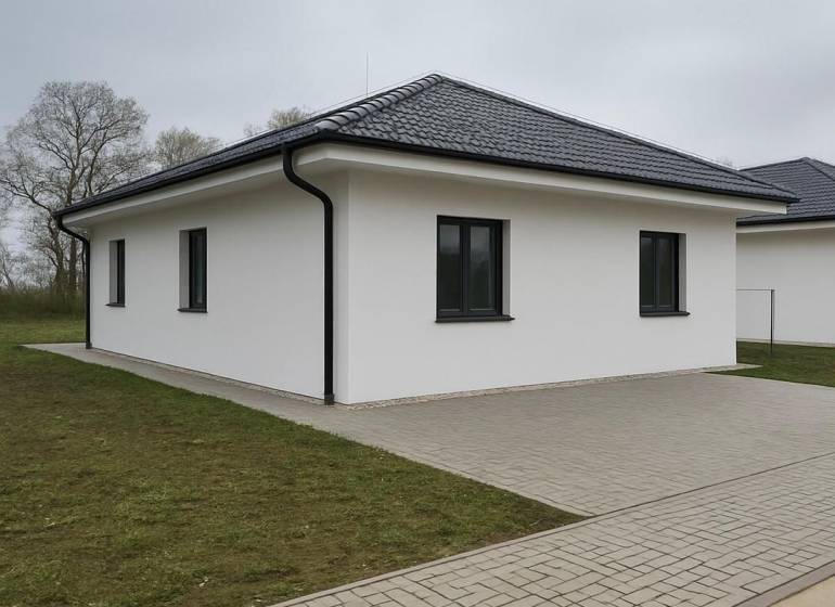 A family house in Cífer with a sloped roof and a paved walkway.