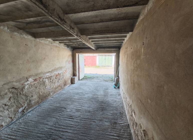 The interior of a garage with a concrete floor and raw walls on Okružná Street in Michalovce.