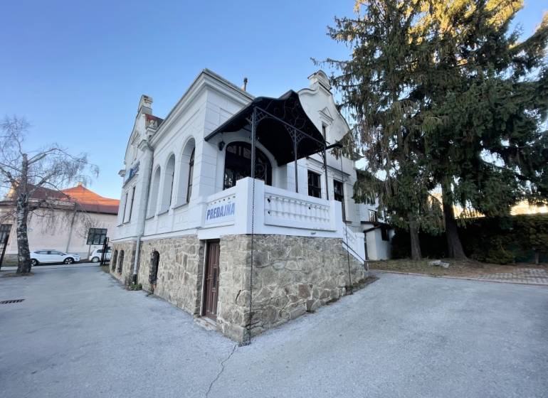 The building on Vajanského Street in Prešov with an elegant stone base and a white facade.