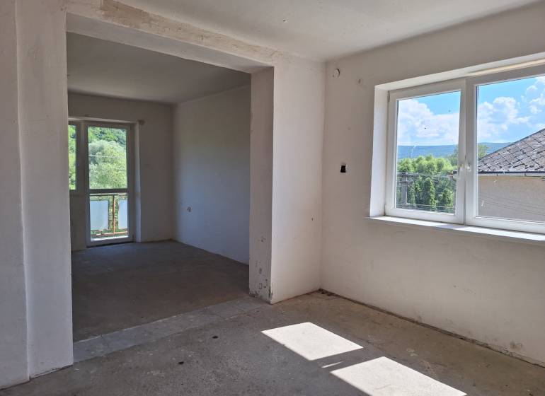 Room in a family house, large windows, view of the garden and surrounding trees.