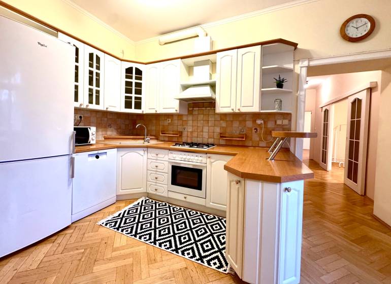 A kitchen in a 4-room apartment with white cabinets and a wood-patterned floor.