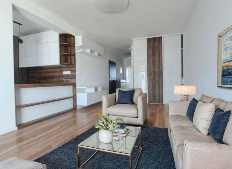 Living room in a two-room apartment with a wooden decor floor and comfortable sofas.