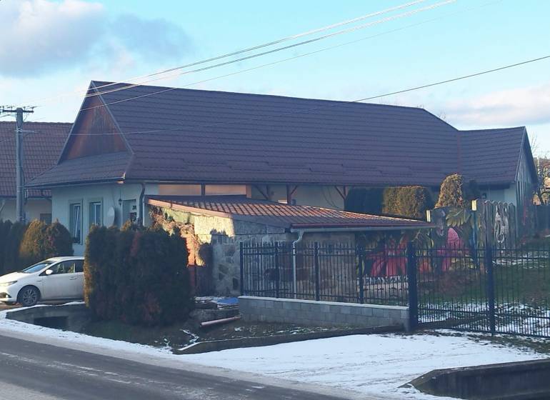 A family house on Dubovska Street in Dobrá Niva, with a garden and cars.