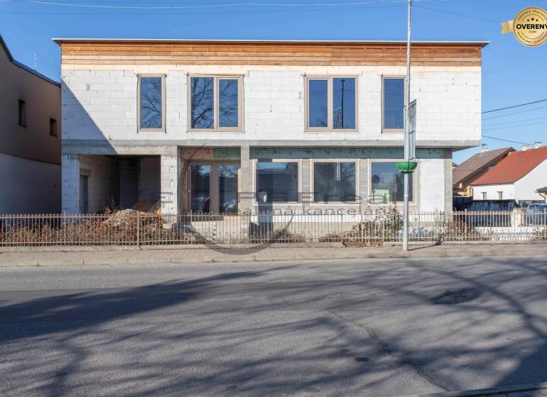 A building in Veľké Leváre with an unfinished facade standing by the road.