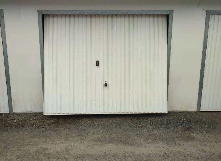 Garage on Urxova Street in Prešov with white doors on a gravel surface.