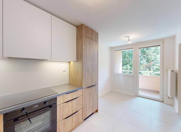 A kitchen with a built-in oven and wooden decor doors in a 4-room apartment.