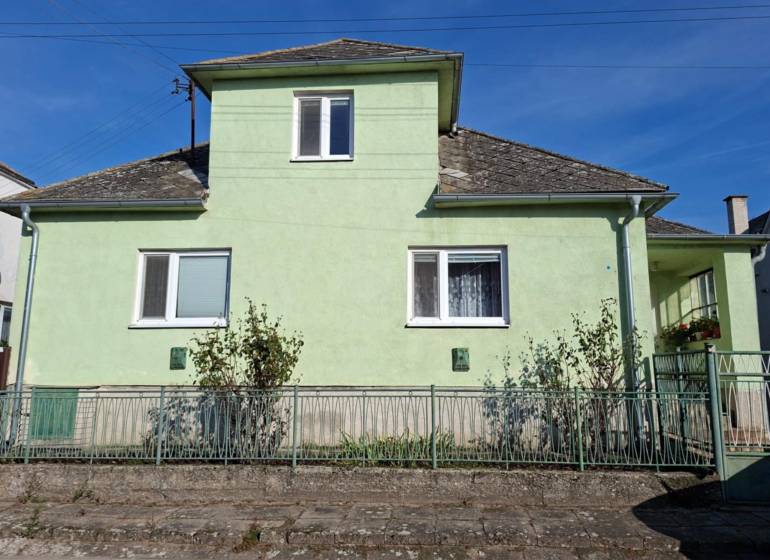A family house in Malé Leváre with a light green facade and a steep roof.