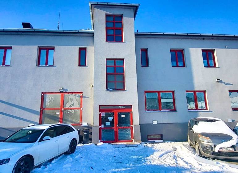 The facade of the office on Osloboditeľov in Košice - Barca district, cars parked on a snowy area.