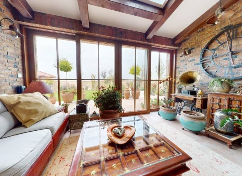 Interior of a family house with historical decorations and large windows, floor with wooden decor.
